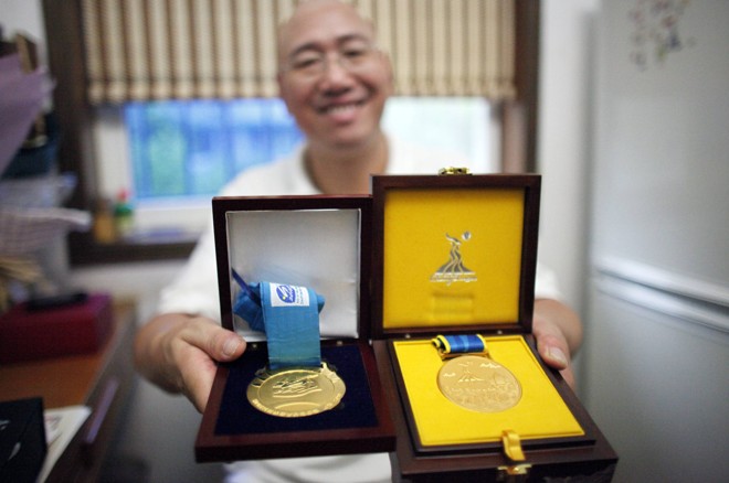 O pai, Qingsong Ye, exibe algumas das medalhas da filha |