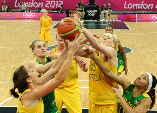 Jogadoras de Brasil e Austrália disputam a bola no torneio olímpico. |