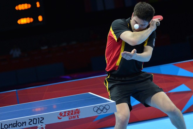 O alemão Dimitrij Ovtcharov saca contra Tang Peng, de Hong Kong, na disputa do bronze no tênis de mesa | 