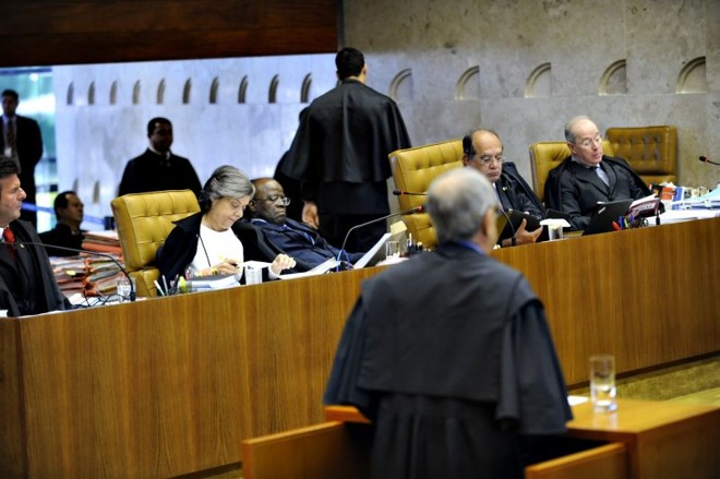 Joaquim Barbosa (ao centro), quase deitado, em sua cadeira: ministro tem dores na coluna e, ao longo do primeiro dia, retirou-se da sessão para repousar em uma sala ao lado do plenário |