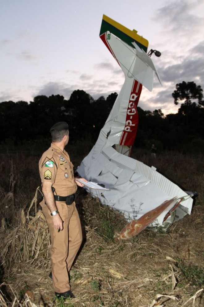 Policial observa os destroços da aeronave. |