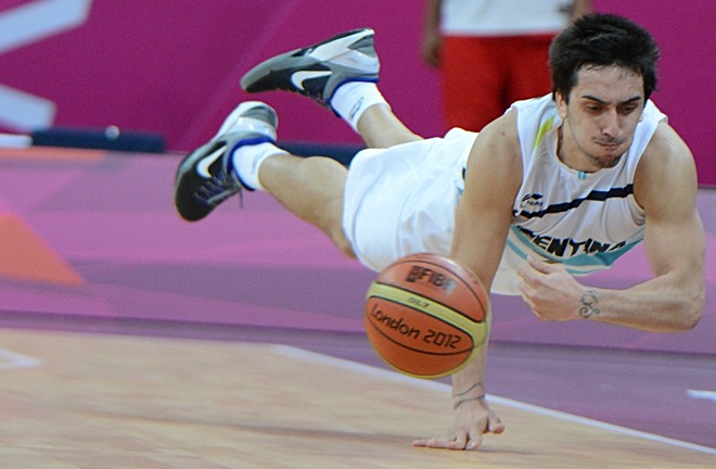 A ala argentino Leonardo Gutierrez voa para evitar a saída da bola em duelo com a Tunísia, no basquete masculino | 