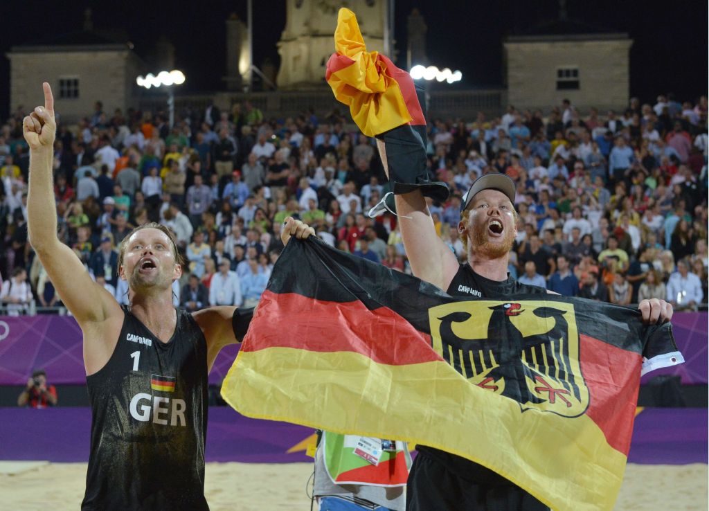Brink e Reckermann com a bandeira alemã: primeiro ouro de um esporte que começou a existir no país europeu há 20 anos | Saeed Khan/ AFP