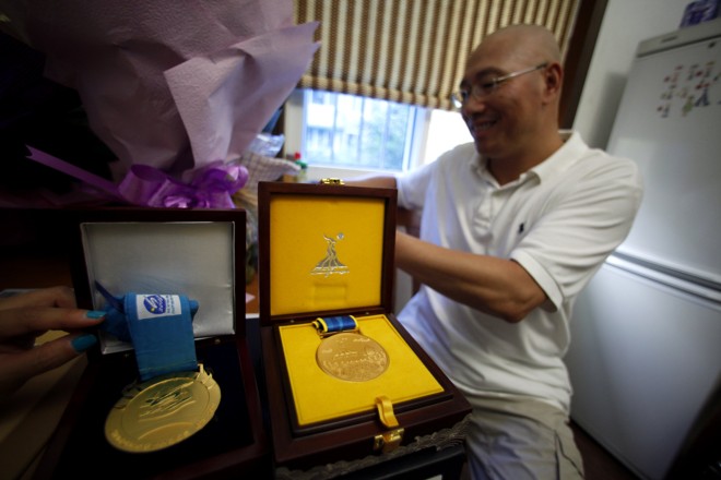 O pai, Qingsong Ye, exibe algumas das medalhas da filha |
