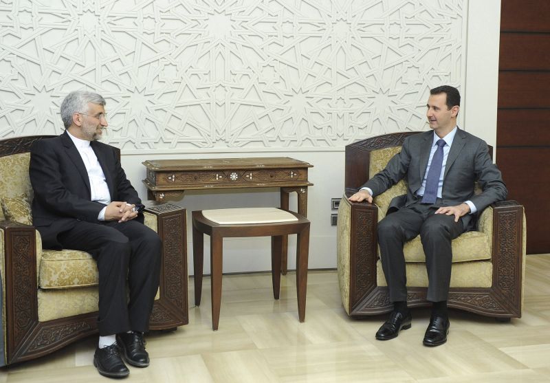 Assad (à dir.) é visto em encontro com o secretário iraniano Saeed Jalili, em foto distribuída pela agência estatal Sana | Reuters/SANA/Divulgação