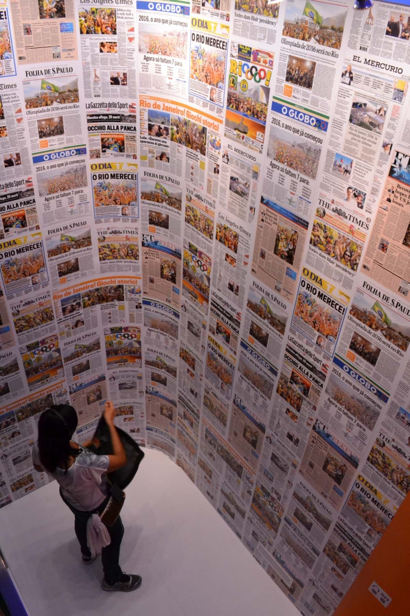 Visitante observa capas de jornais do dia seguinte ao que o Brasil foi escolhido como país-sede da Olimpíada de 2016 na exposição da Casa Brasil | Marco Sanchotene, enviado especial/ Gazeta do Povo