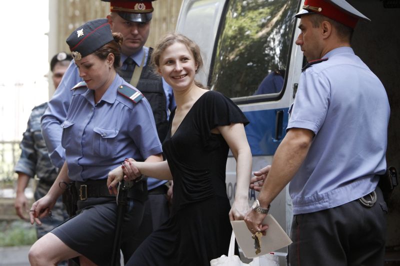 Uma das integrantes do grupo, Maria Alyokhina, é escoltada por policiais para uma audiência do caso, em Moscou | Reuters/Maxim Shemetov