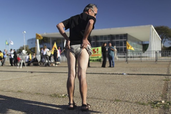 Homem puxa o short para cima em protesto na frente do STF |