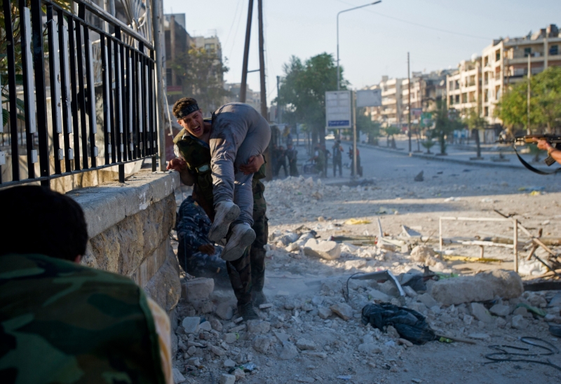 Rebelde carrega o corpo de seu irmão, morto em Aleppo | Zac Baillie/AFP