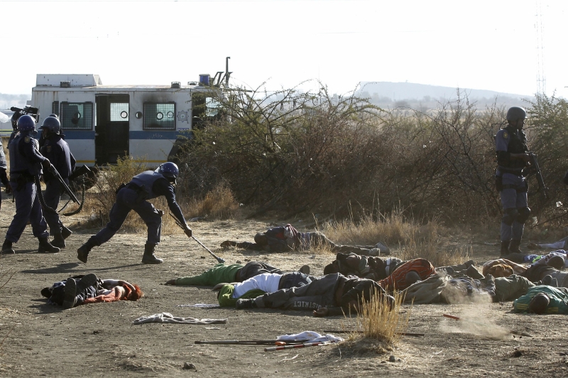 Policial examina corpos de mineiros mortos em confronto perto de uma mina em Marikana | Siphiwe Sibeko/Reuters