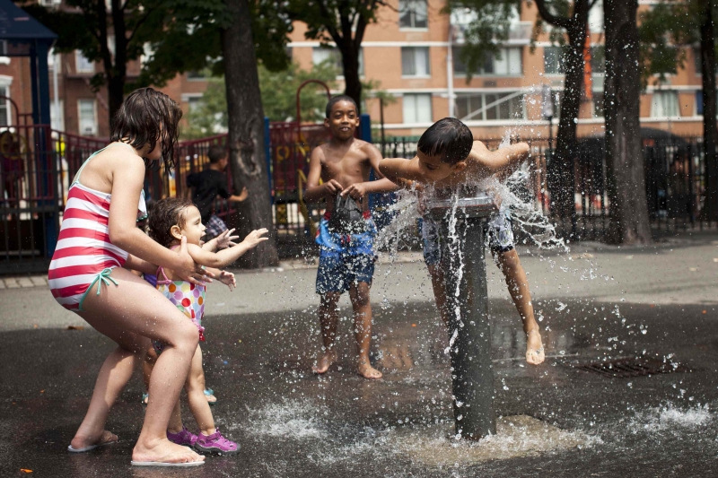 Crianças se refrescam em fonte de Nova York, que registrou temperatura de 32oC nesta semana | Andrew Burton/Reuters