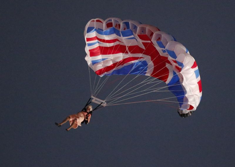 Um artista interpretando a rainha Elizabeth, da Grã-Bretanha, pula de paraquedas de um helicóptero durante a cerimônia de abertura dos Jogos de Londres, no Estádio Olímpico, na semana passada | REUTERS/Fabrizio Bensch