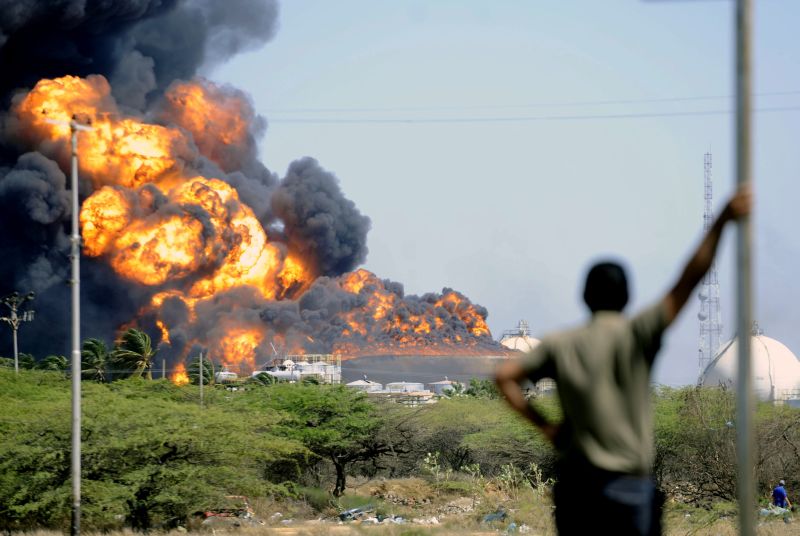 Foto de domingo (26) mostra a altura das chamas do incêndio que atingiu a maior refinaria da Venezuela | AFP Photo/Leo Ramirez