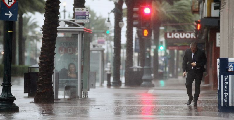 Homem caminha sob chuva e vento forte por ruas de Nova Orleans: cidade aguarda a chegada do furacão Isaac | Mario Tama/Getty Images/AFP