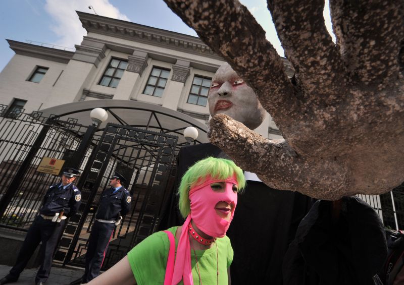 Manifestantes em frente à embaixada russa em Kiev, na Ucrânia, protestam contra a prisão da banda Pussy Riot | AFP PHOTO / GENYA SAVILOV