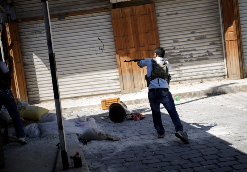 Rebelde dispara contra forças do governo na região de al-Jadeida, onde mora a minoria cristã de Aleppo | Phil Moore/AFP