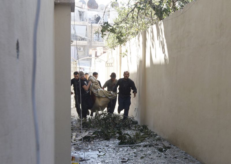 Membros do Exército Livre da Síria carregam vítima em Aleppo. | Zain Karam/ Reuters