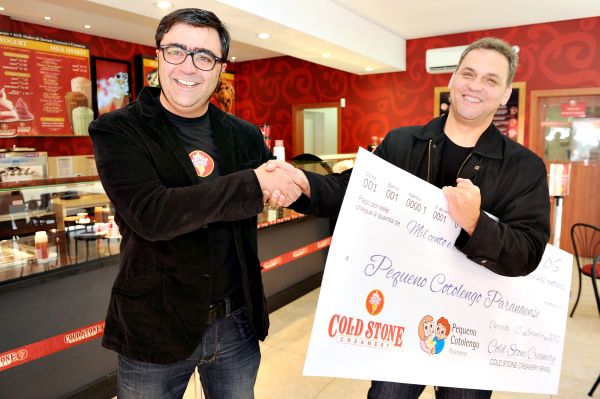 O diretor do Pequeno Cotolengo, Padre Rodinei Thomazella (à dir.), recebeu no último dia 5 um cheque de Joaquin Fernandez Presas (à esq.), sócio-diretor da recém-inaugurada Cold Stone Creamery, primeira loja da multinacional americana de sorvetes do Brasil. O valor é referente ao lucro do primeiro dia de funcionamento | Guadalupe F. Presas