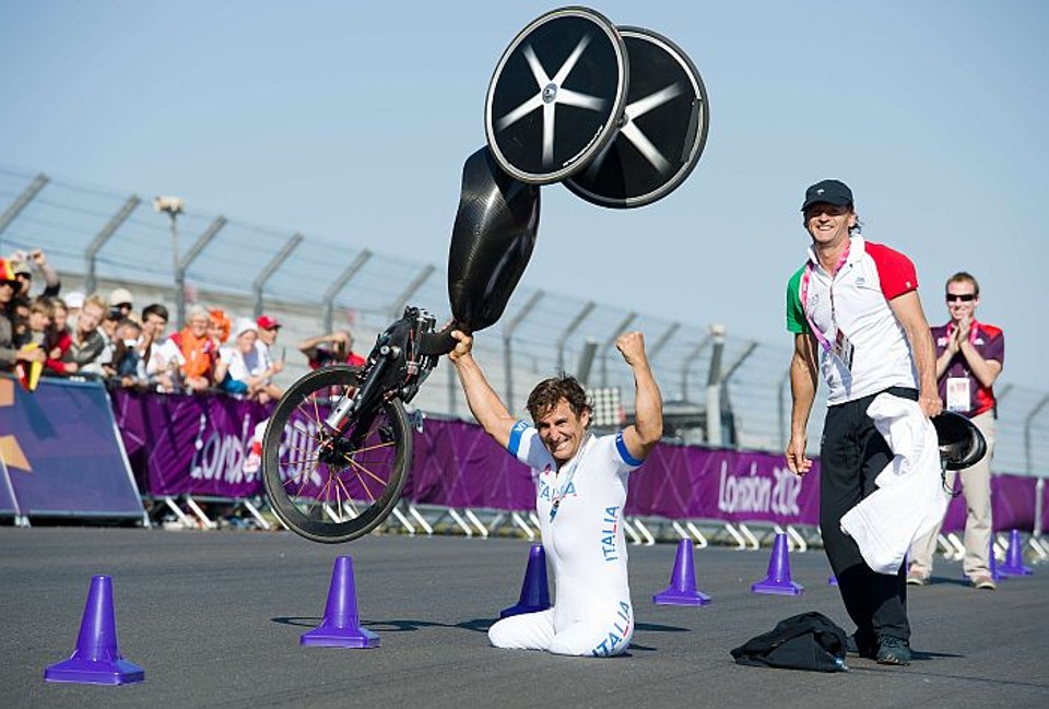 Alessandro Zanardi ergue a bicicleta adaptada após a conquista do ouro na prova de contrarrelógio na Paralímpiada de Londres | AFP