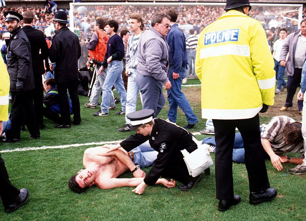 Policial atende torcedor no gramado do Estádio de Hillsborough: depois da tragédia, o futebol inglês mudou radicalmente | AFP