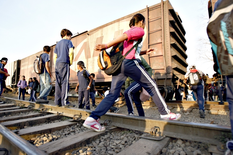 Ao sair da escola, crianças e adolescentes pulam trem na Vila Audi, na última quarta-feira. Ritual se repete duas vezes por dia | Henry Milleo/ Gazeta do Povo