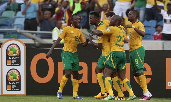 Homem segura pedra enquanto corre da polícia | REUTERS/Siphiwe Sibeko