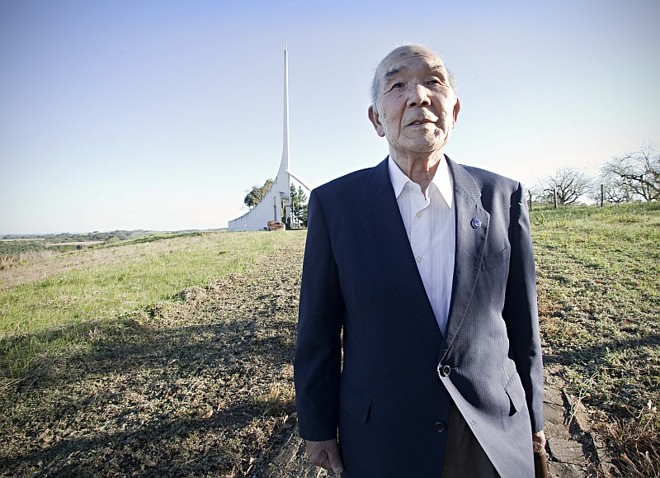 Kazumi em primeiro plano e ao fundo com o gigante pássaro tsuru: monumento construído para pedir paz |
