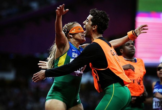 Brasileira Terezinha Guilhermina comemora o ouro nos 200 m na categoria T11 com o guia Guilherme Santana | 