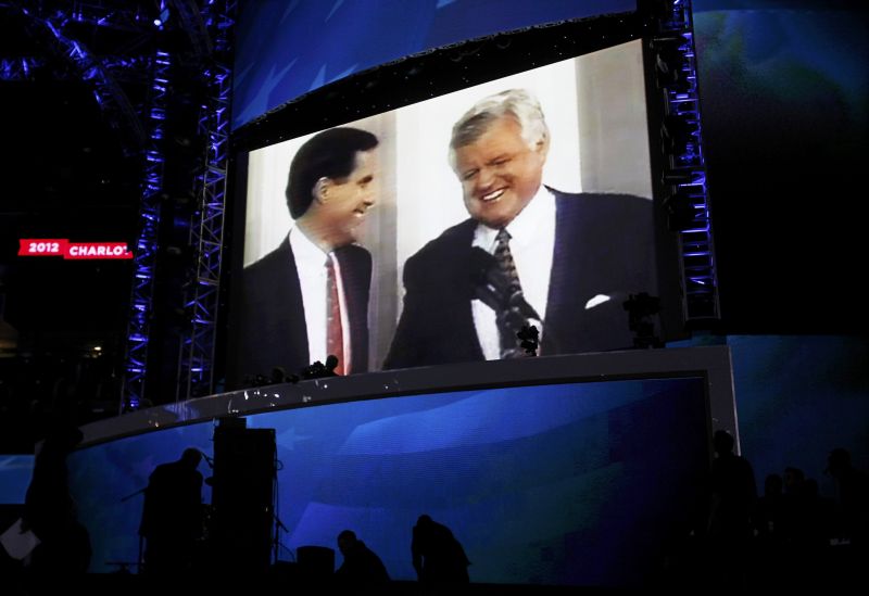 Mitt Romney (à esq.) aparece em vídeo junto com o falecido senador democrata Ted Kennedy | Reuters/Jessica Rinaldi