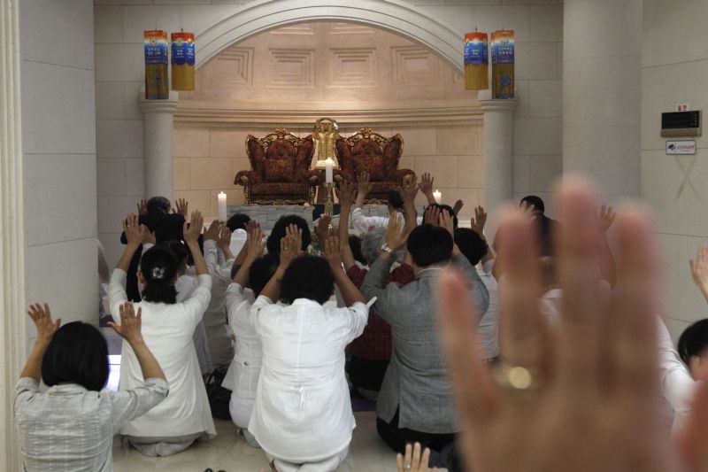 Fiéis rezam em Seul em frente a uma estátua do reverendo Sun Myung Moon, fundador da Igreja da Unificação, que morreu neste domingo (2) | Reuters/Kim Hong-Ji