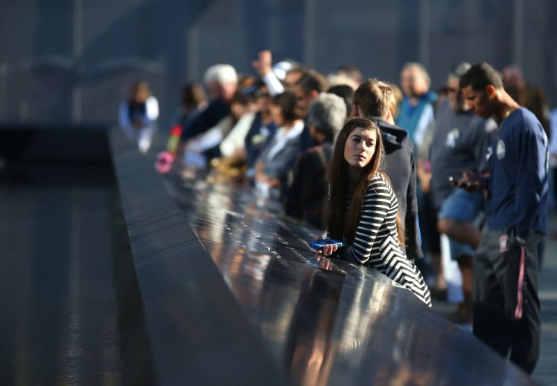 Em Nova York, familiares e amigos observam um minuto se silêncio em homenagem às vítimas dos atentados de 11 de Setembro | AFP Photo/Chang W. Lee/Compartilhamento