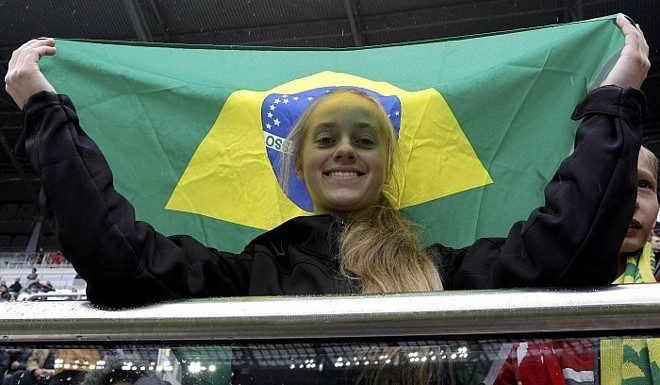 Menina polonesa segura a bandeira do Brasil na vitória sobre o Japão: prefeitura de Wroclaw liberou os estudantes das aulas para acompanhar o amistoso | 
