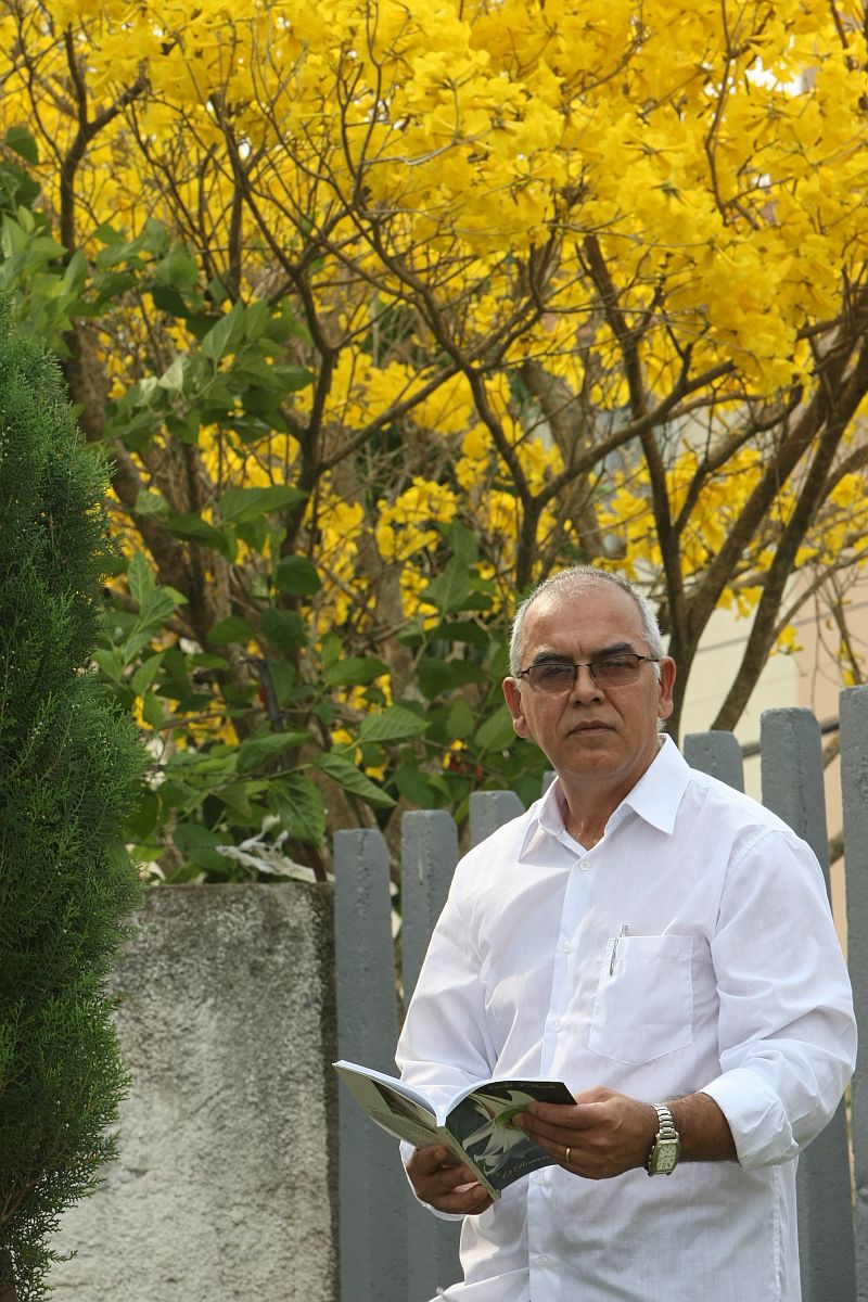 Cândido Miranda e um dos livros que deixa por aí, à mercê de quem os encontrar: Não há felicidade igual | Aniele Nascimento/ Gazeta do Povo