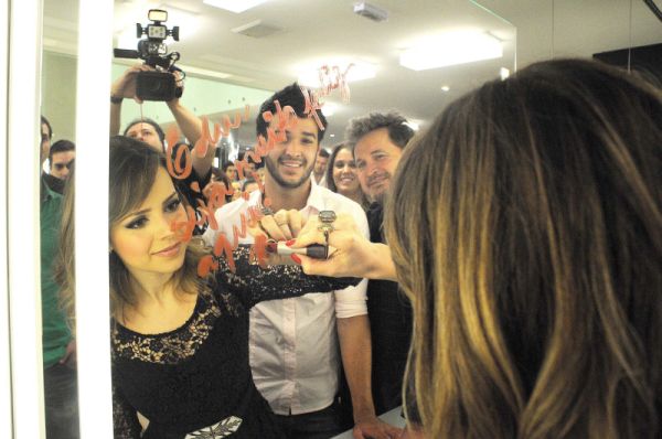 Celebridade mais assediada na festa de inauguração do salão W Crystal, Sandy deixou um recado no espelho para o cabeleireiro Eduardo Nunes, sobrinho de Wanderley Nunes (ambos ao fundo). Edu é quem cuida do cabelo da cantora junto com Wanderley | Kraw Penas