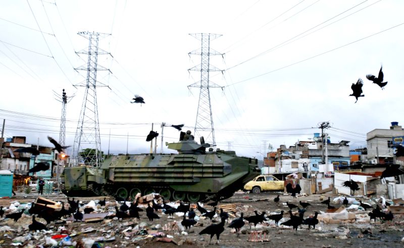 Blindados transitam em meio ao lixo na rua: Índice de Desenvolvimento Humano (IDH) de Manguinhos é um dos piores do Rio | Sergio Moraes / Reuters