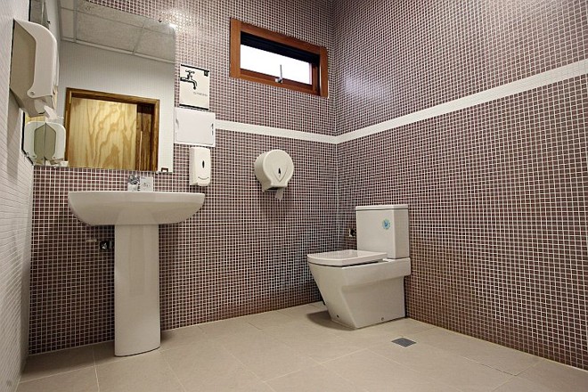 Parece pastilha cerâmica, mas não é. O banheiro é revestido com plástico feito com produtos reaproveitados |