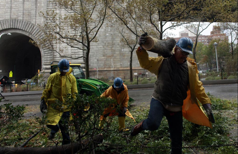 Funcionários retiram uma árvore caída de uma rua de Nova York, após a passagem da tempestade Sandy | Allison Joyce/Getty Images/AFP