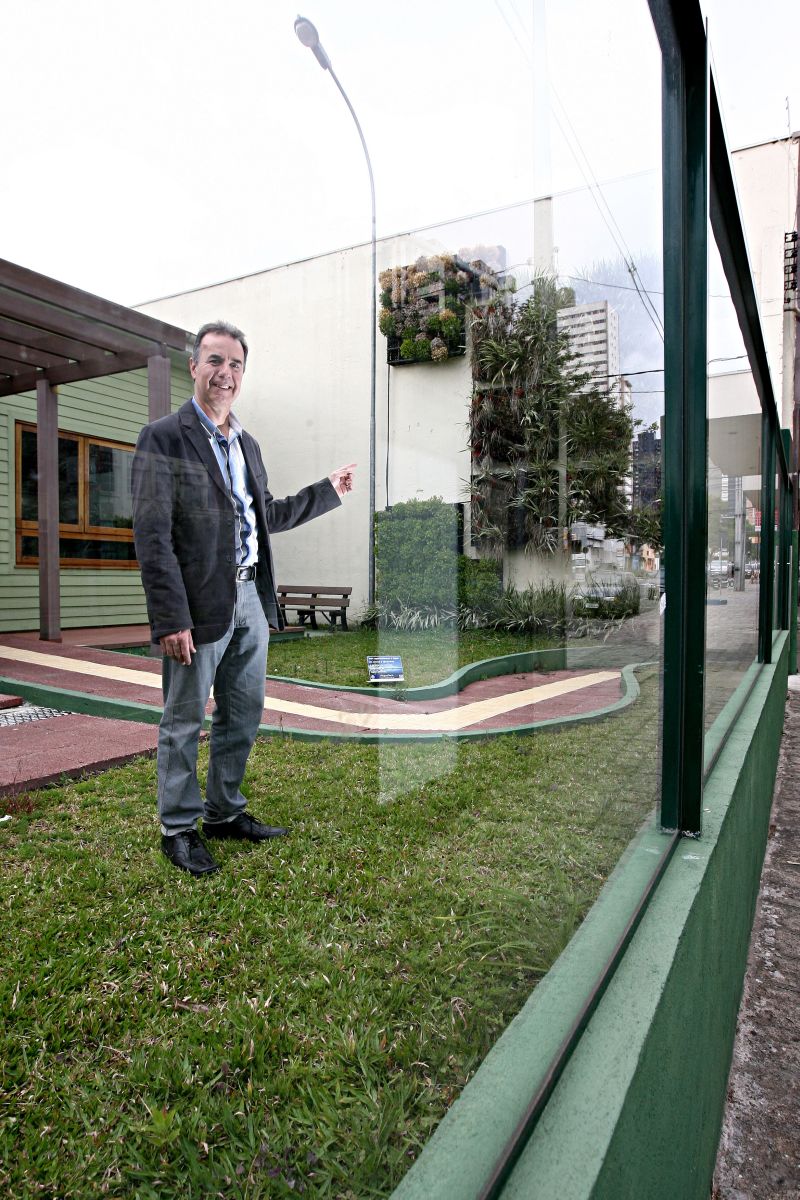 Eloy Casagrande diante do vidro que serve de muro no Escritório Verde: estrutura permite ver a obra da calçada e ainda diminuiu o barulho vindo da rua | Felipe Rosa/Gazeta do Povo