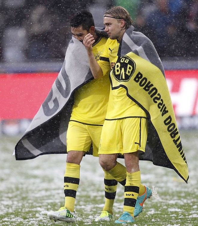 Guendogan e Schmelzer, do Borussia Dortmund, tentam se proteger da neve após vitória so Freiburg | 