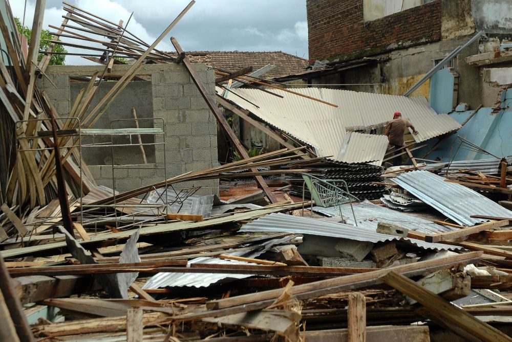 Homem caminha em meio à destruição causada pelo furacão Sandy em Cuba | AFP Photo/STR