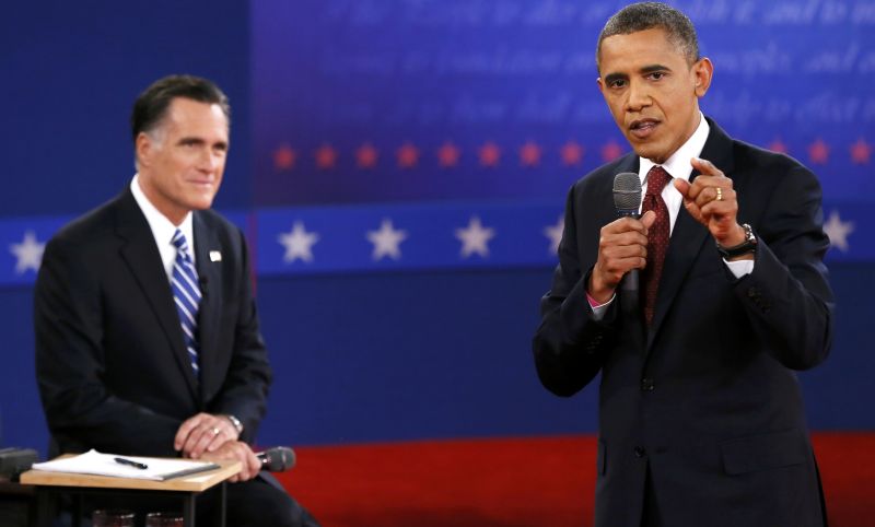 Barack Obama (à direita) responde a pergunta da plateia, enquanto é observado por seu adversário republicano Mitt Romney durante debate em Nova York | REUTERS/Rick Wilking