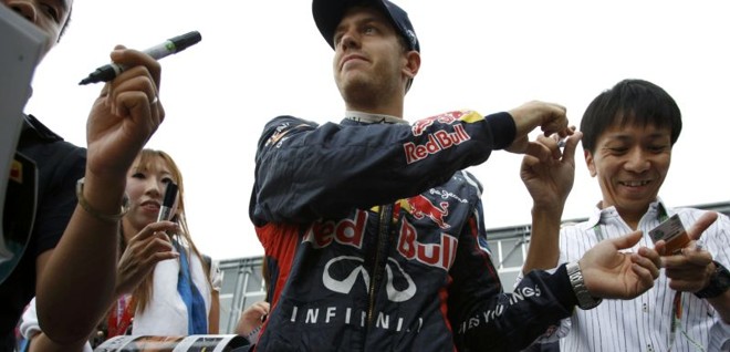 Piloto da Red Bull, Sebastian Vettel, atende fãs após ganhar a pole em treino classificatório no Japão | REUTERS/Issei Kato