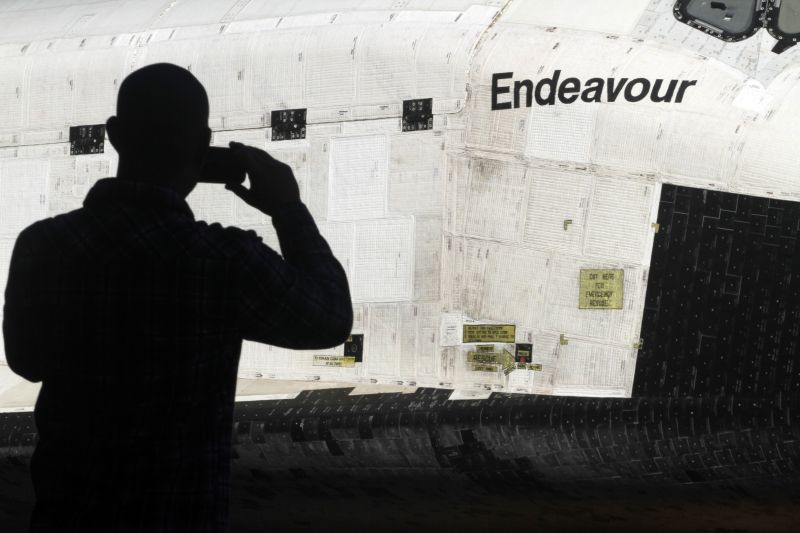 Homem fotografa a nave espacial Endeavour no seu trajeto para o museu, pelas ruas de Los Angeles | Reuters