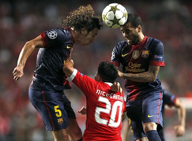 Gaitán, do Benfica, disputa a bola com Puyol e Daniel Alves, do Barcelona | 