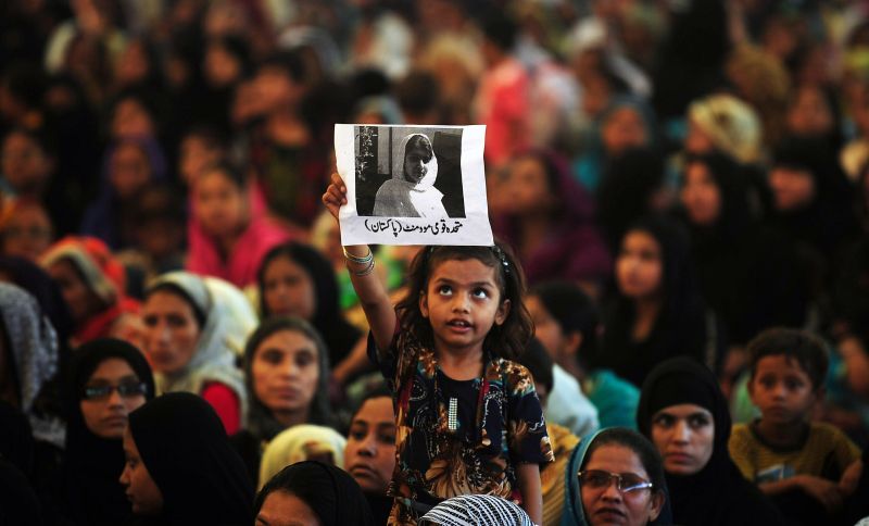 Menina segura fotografia de Malala Yousafzai durante protesto | Rizwan Tabassum/ AFP