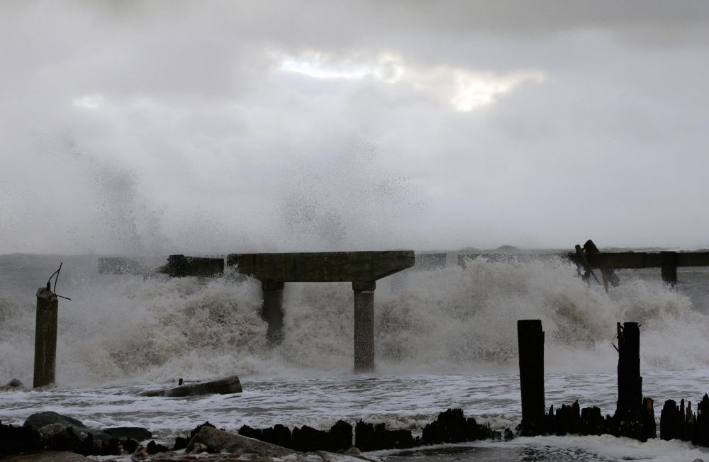 Ondas quebram em uma parte demolida de um pier em no final da avenida Pacific, norte de Nova York | Reuters/Tom Mihalek
