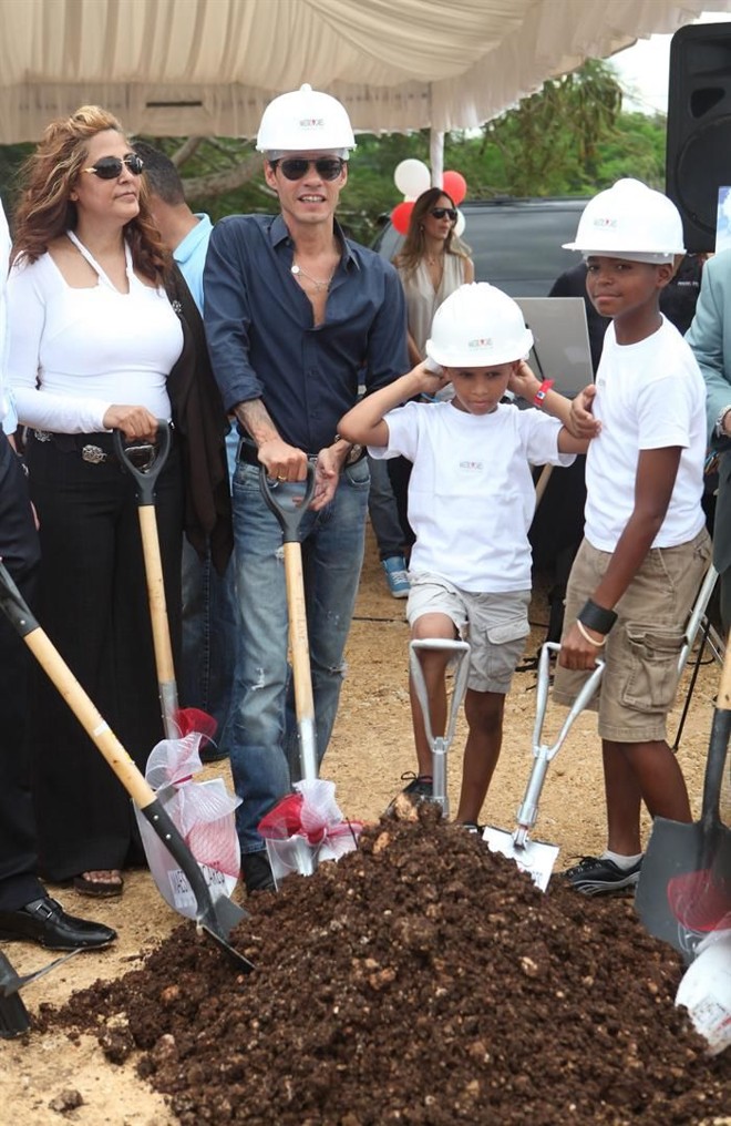 Marc Anthony posa com crianças e com a futura diretora do orfanato, Sonia Hanes, no local onde será construído o orfanato | 