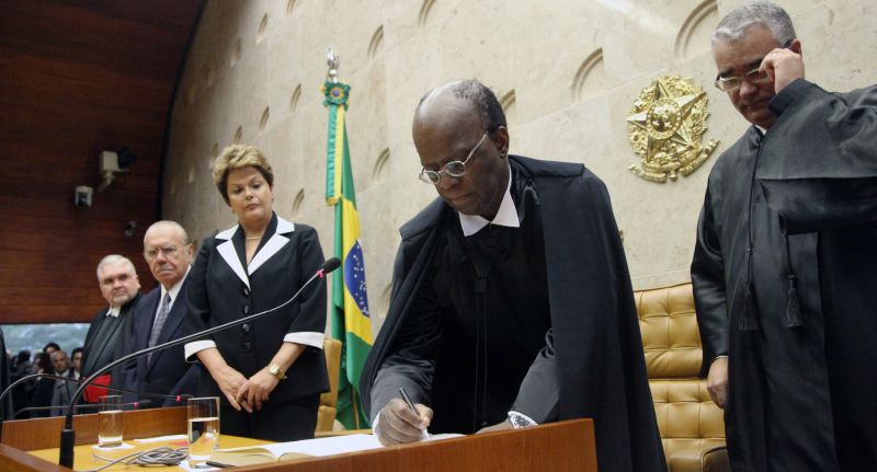 Joaquim Barbosa assina o termo de posse como presidente do Supremo, observado pela presidente: Dilma Rousseff não se curvou à ala do PT que queria que ela não fosse à posse | Carlos Humberto/STF