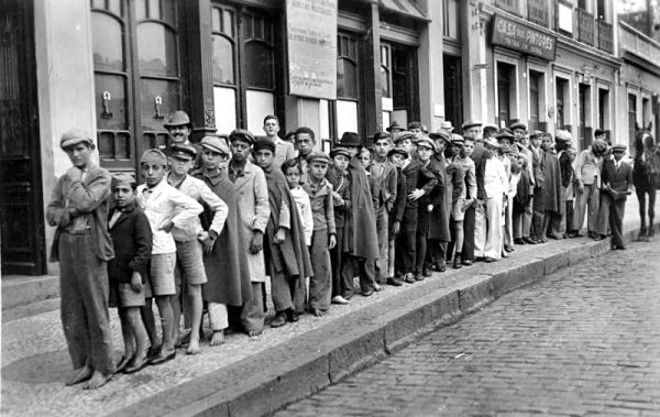 Hoje o trabalho infantil não é permitido. Na fotografia feita no início da década de 1940 vemos um grupo de crianças e jovens jornaleiros, cujos trajes e pés descalços mostram que a pobreza os obrigava a trabalhar |