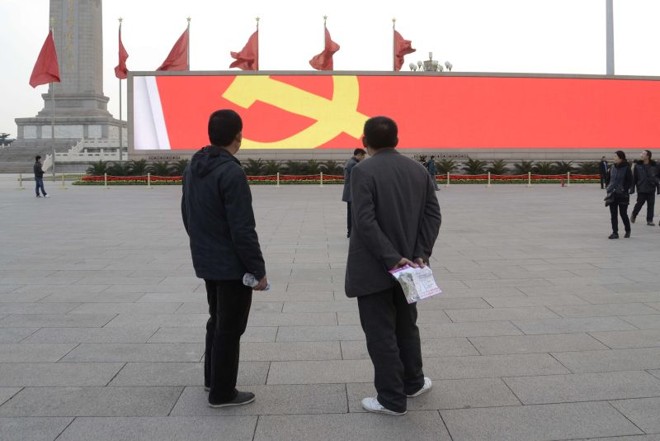 Chineses observam símbolo do Partido Comunista, em Pequim |